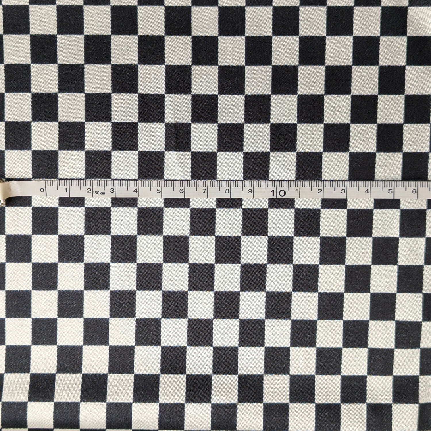 Black and white checkered fabric with a ruler for scale