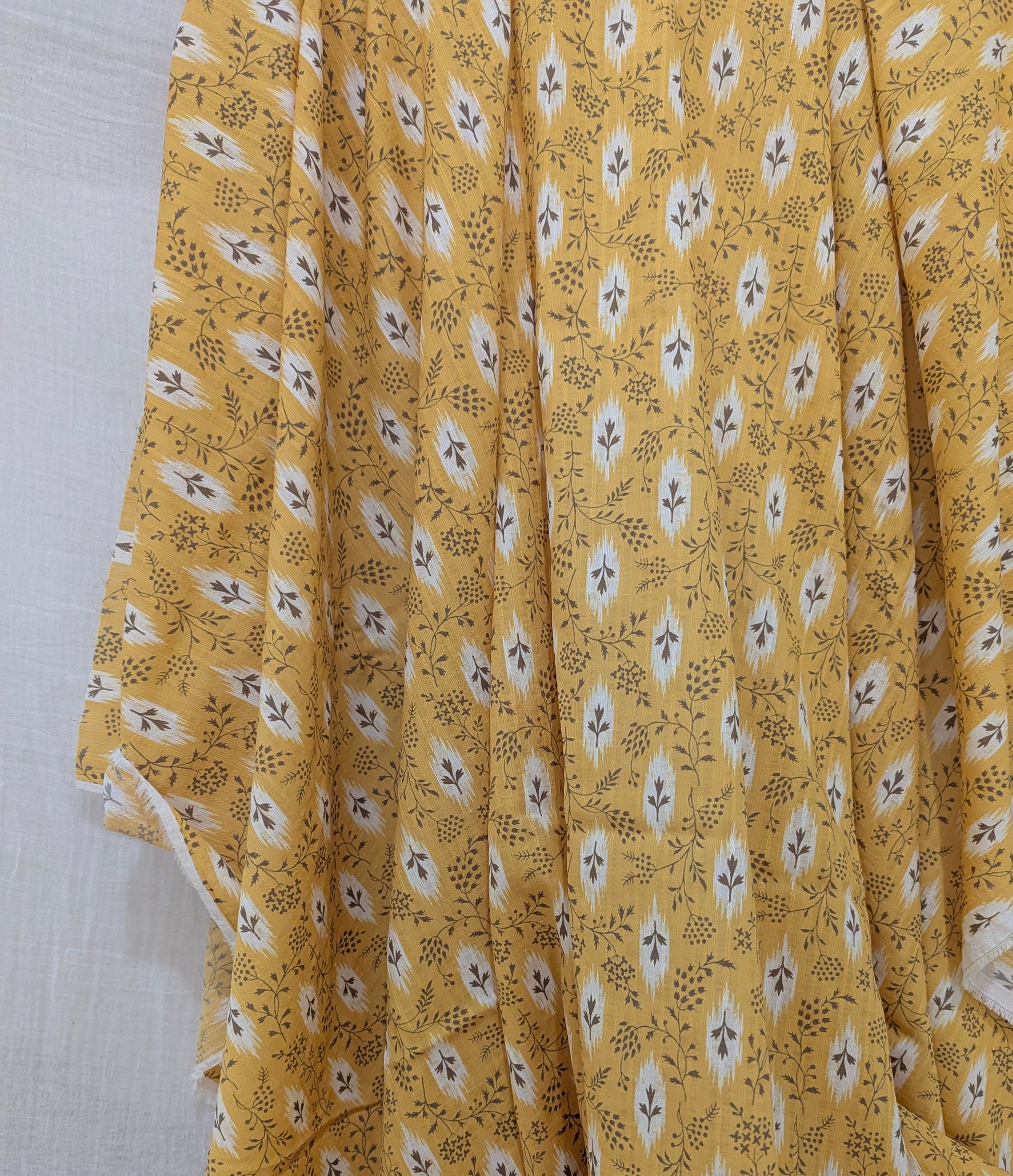 Yellow fabric with small floral pattern on a white background