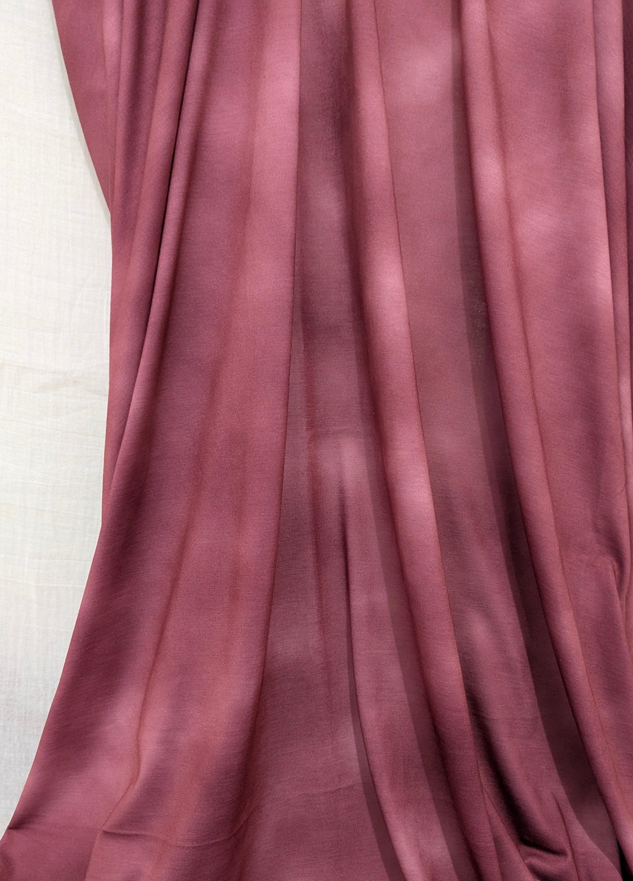 Mauve fabric draped over a white surface
